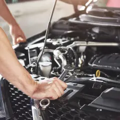 Mechanik naprawia silnik samochodu w leasingu. Awaria auta wymaga interwencji.