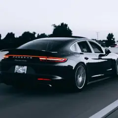 Czarny Porsche Panamera Turbo jedzie autostradą. Tablica rejestracyjna CVC-911. Limit 150 tys. VAT-26.