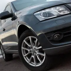Duże auto terenowe z błyszczącym lakierem stoi przy wodzie.