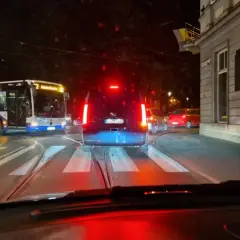 Nocne miasto, tramwaje i samochody. Nagłe hamowanie przepisów ruchu drogowego, gdy kierowca widzi czerwone światło.