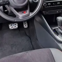 Wnętrze samochodu z pedałami i dźwignią zmiany biegów. Wybór między automat a manual jest widoczny.