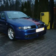 Niebieski Seat Leon z czerwonym pasem na masce, gotowy do modyfikacji. Dowiedz się, jak tuningować auto, by wyglądało jeszcze lepiej!