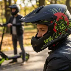 Mężczyzna w kasku z motywem samuraja na hulajnodze elektrycznej. Czy na hulajnodze elektrycznej trzeba mieć kask? Bezpieczeństwo przede wszystkim!
