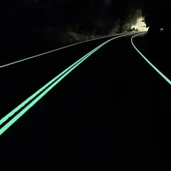 Nocny ruch w Australii. Droga z fosforyzującymi pasami prowadzi przez ciemność, tworząc magiczny widok.