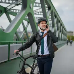 Biznesmen na rowerze rozmawia przez telefon, zastanawiając się nad zakupem roweru na firmę a VAT.