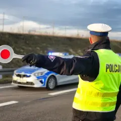Policjant kieruje ruchem, sygnalizując zatrzymanie. Nowe przepisy drogowe w praktyce.