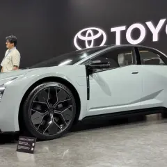 Nowoczesna Toyota Corolla Concept, zapowiedź przyszłych generacji, prezentowana na tle logo Toyota.