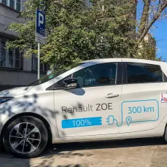 Biały Renault ZOE ładuje się na stacji. Czy samochód elektryczny się opłaca? Zasięg 300 km sugeruje, że tak.