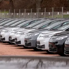 Rząd białych i szarych samochodów elektrycznych czeka na odbiór. To przyszłość polskiej motoryzacji, która powstaje w naszej fabryce samochodów elektrycznych.