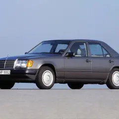 Szary Mercedes W124, symbol najbardziej niezawodnych samochodów, stoi na płaskiej nawierzchni.