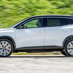 Biały Renault Austral w ruchu, z widocznym kierowcą. Jego dynamiczna sylwetka i nowoczesne linie podkreślają jego wymiary.