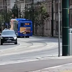 Policjant w kamizelce odblaskowej stoi przy ulicy, kontrolując ruch. Czy radiowóz musi być widoczny, by zapewnić bezpieczeństwo?