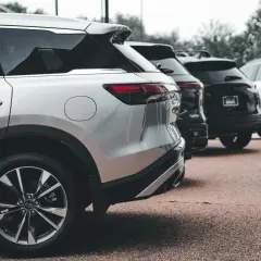 Rzędy lśniących SUV-ów, w tym srebrny model z silnikiem wolnossącym, czekają na swoich właścicieli.