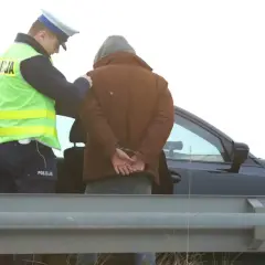 Policjant zakłada kajdanki zatrzymanemu mężczyźnie. Nowelizacja kodeksu karnego w praktyce.