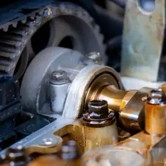Widok na mechanizm rozrządu w aucie: pasek zębaty, koła zębate i wałek rozrządu.