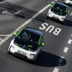 Czy elektryki mogą jeździć buspasem? Dwa biało-zielone BMW i3 jadą buspasem, jeden z nich jest bliżej kamery.
