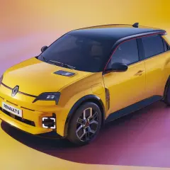 Żółty samochód elektryczny Renault 5 z czarnym dachem i czerwonym akcentem.