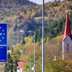 Granica Słowacji i Polski. W tle jesienne wzgórza i wieża kościoła. Fotoradary słowacja pilnują porządku.
