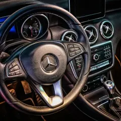 Wnętrze Mercedesa z kierownicą i deską rozdzielczą. Idealne do wynajem samochodu powyżej 150 tys. km.