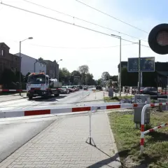 Przejazd kolejowy z opuszczonymi rogatkami i czerwonymi światłami. Kierowca ciężarówki może otrzymać mandat za przejazd kolejowy, jeśli zignoruje sygnały.