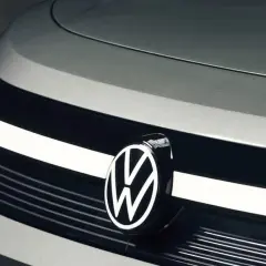 Zbliżenie na przód nowoczesnego samochodu, z widocznym logo Volkswagen. Nowe modele tej marki zachwycają designem.
