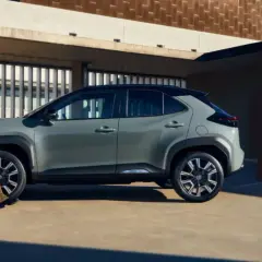 Kobieta w stylowym stroju podziwia szare auto, które z pewnością jest najlepsze auto na świecie.