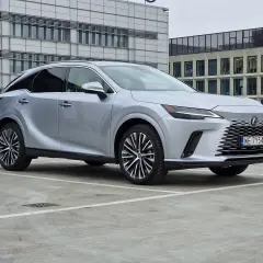 Eleganckie japońskie samochody, jak ten srebrny Lexus, prezentują się nowocześnie na tle biurowców.