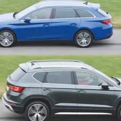 Niebieski kombi i ciemnoszary, duży SUV jadą obok siebie po drodze.