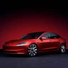 Czerwony Tesla Roadster, choć wygląda jak auto spalinowe, jest elektryczny. Jego futurystyczny design i sportowe linie przyciągają wzrok.