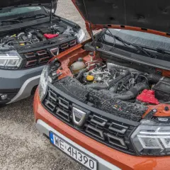 Dwa silniki Dacia Duster, szary i pomarańczowy, z otwartymi maskami. Który wybrać: diesel czy benzyna?