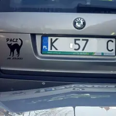 Czarny kot na klapie bagażnika z napisem "PACZ JAK JEDZIESZ". Tablica rejestracyjna K 57 C.