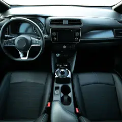 Wnętrze nowoczesnego auta elektrycznego. Kierownica, deska rozdzielcza z ekranem, fotele. Idealne miejsce, by sprawdzić wyposażenie auta.