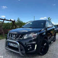 Czarny Suzuki Vitara 1.4 Boosterjet, z chromowanym grillem i zderzakiem, stoi na żwirze. Czyżby awarie?