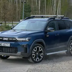 Ciemnoniebieski SUV z bagażnikiem dachowym, idealny na podróże. To najlepsze auto na gaz, gotowe na każdą drogę.