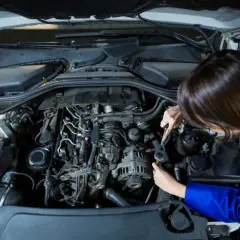 Mechanik naprawia silnik, szukając przyczyny braku mocy w aucie.