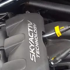 Silnik SKYACTIV TECHNOLOGY, serce oszczędnych silników benzynowych, z widocznymi przewodami i złączkami.