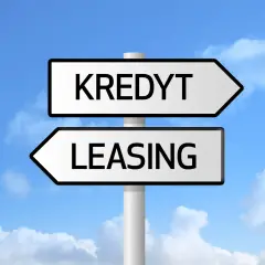 Znak drogowy z napisami "KREDYT" i "LEASING" pod niebieskim niebem z chmurami. Wybór między finansowaniem a zdolnością kredytową.