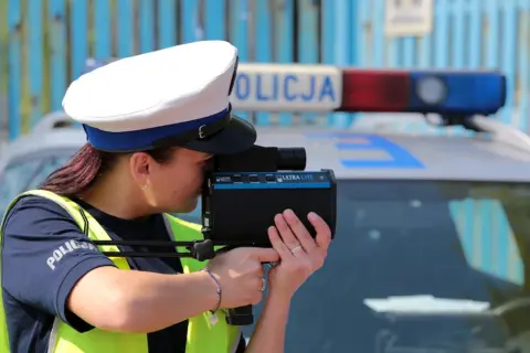 Policjantka mierzy prędkość z bliskiej odległości za pomocą radaru.