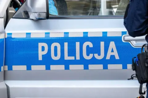 Policjant przy radiowozie z napisem POLICJA. Czyżby nowe mandaty?