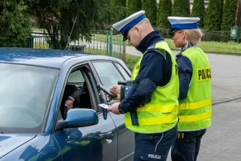 Policjant kontroluje dokumenty kierowcy, który może być bliski pobicia rekordu punktów karnych.