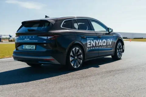 Ciemny Skoda Enyaq iV, jeden z popularnych SUVów, na drodze testowej.
