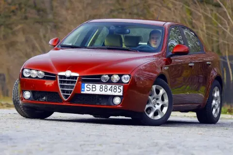 Czerwone Alfa Romeo 159 z kierowcą. Zastanawiasz się, jaki silnik ma to Alfa Romeo 159?