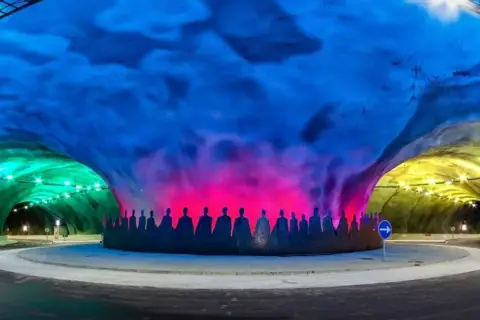 Kolorowy, najdłuższy tunel w Europie z sylwetkami ludzi na ścianie.