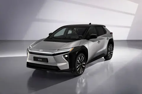 Srebrny Toyota bZ4X z czarnym dachem, gotowy na długie podróże. Ten elektryczny SUV oferuje imponujący zasięg.