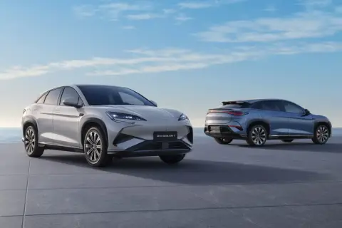 Dwa nowoczesne SUV-y marki BYD, jedne z wielu chińskich marek samochodów, prezentują się na tle błękitnego nieba i morza.