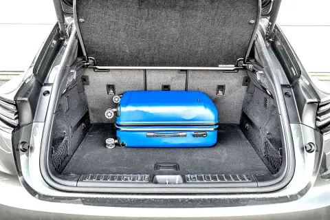 Bagażnik Porsche Macan, z niebieską walizką, pokazuje, jak kompaktowe są jego wymiary.