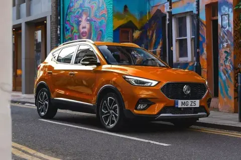 Pomarańczowy MG ZS na tle kolorowego muralu. Czy to marka MG? Tak, to MG!