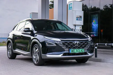 Czarny Hyundai na wodór zaparkowany przy stacji tankowania. Nowoczesny design i ekologiczne paliwo.