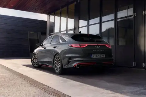 Nowoczesna Kia Proceed, której historia sięga Korei Południowej, prezentuje się dynamicznie na tle architektonicznego budynku.