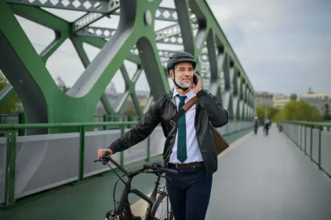 Biznesmen na rowerze rozmawia przez telefon, zastanawiając się nad zakupem roweru na firmę a VAT.